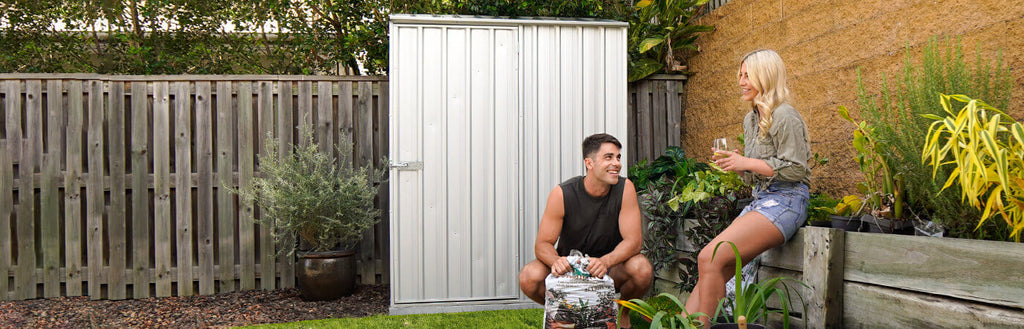 A couple gardening in front of a steel garden shed. 