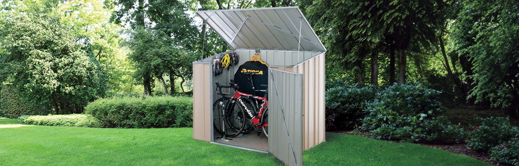 A small steel bike shed with bikes and bike accessories inside in a backyard.